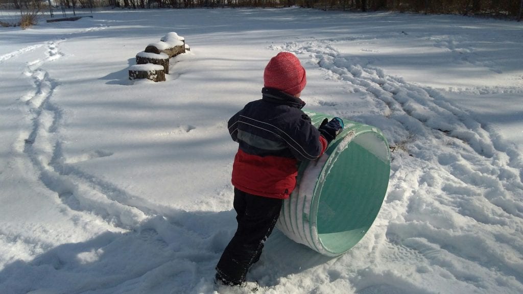 Boy pushes makes a track in the snow with a tunnel